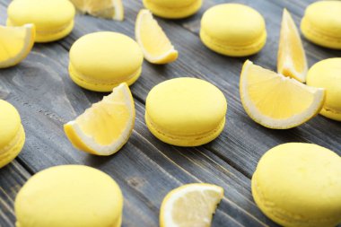Lezzetli taze macarons ve ahşap masa, tatlı limon dilimleri