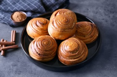 Mutfak masasının üstünde nefis tarçın ile siyah yuvarlak plaka rulo