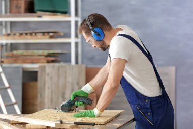 Genç marangoz ahşap testere ile kesme