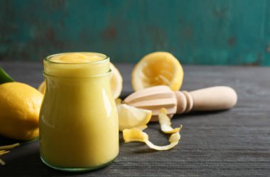 Ahşap masa üzerinde cam kavanoza lezzetli limon lor ile kompozisyon