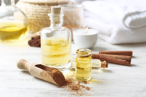 Composition with bottles of cinnamon oil on wooden background — Stock Photo, Image