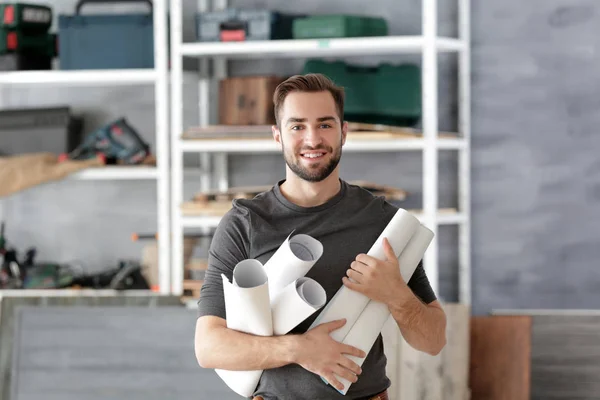 Carpenter holding paper rolls — Stock Photo, Image