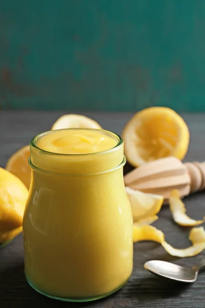 Tarro de vidrio con deliciosa cuajada de limón en la mesa de madera — Foto de Stock