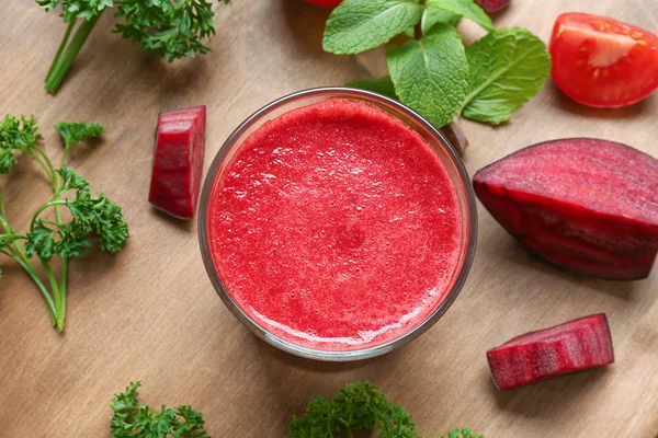 Rode smoothie, verse groenten en kruiden op een houten bord — Stockfoto