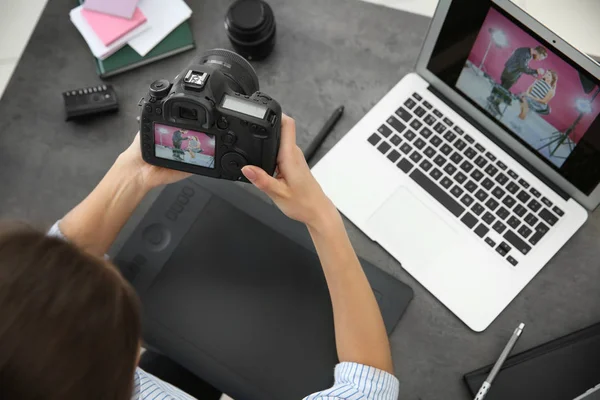 Kvinnlig fotograf med kamera och bärbar dator i office — Stockfoto