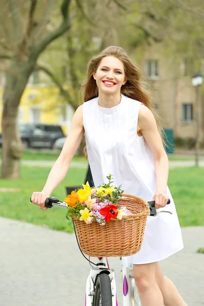 Young smiling girl cycling in park