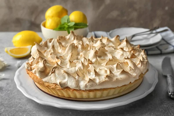 Placa con sabroso pastel de merengue de limón sobre mesa gris, primer plano — Foto de Stock