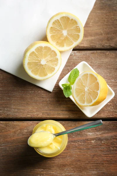 Samenstelling met lekker lemon curd in glazen pot op houten tafel — Stockfoto