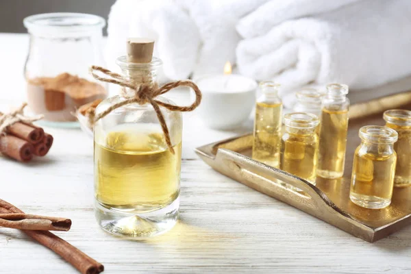 Složení s lahví skořicový olej na dřevěné pozadí — Stock fotografie
