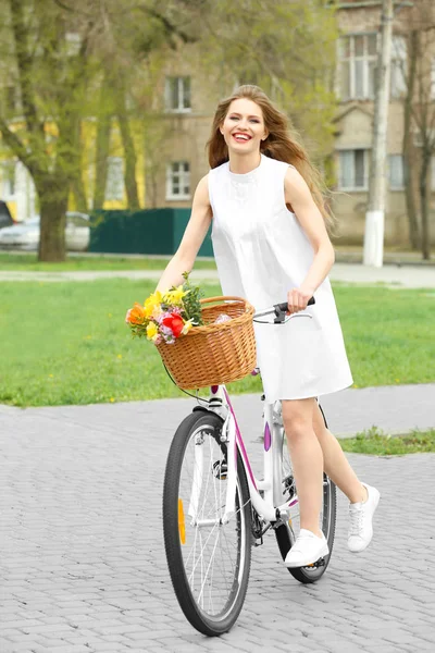 Young smiling girl cycling in park