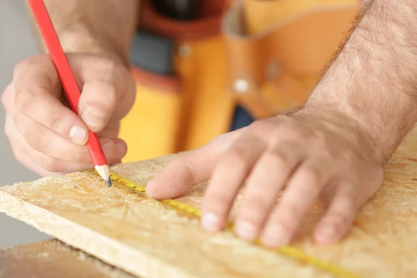 Carpenter applying marking on wooden board in workshop, closeup — Stock Photo, Image