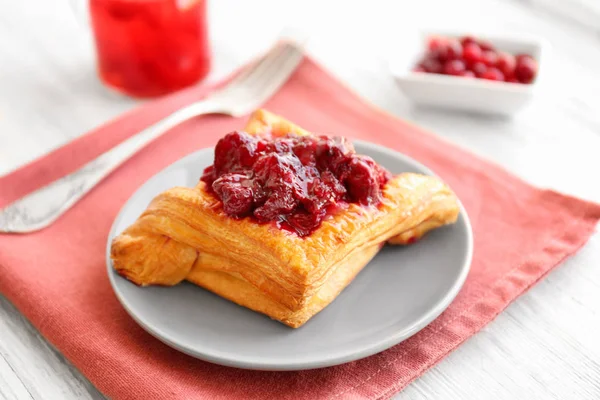 Tasty puff pastry with cherry on plate — Stock Photo, Image
