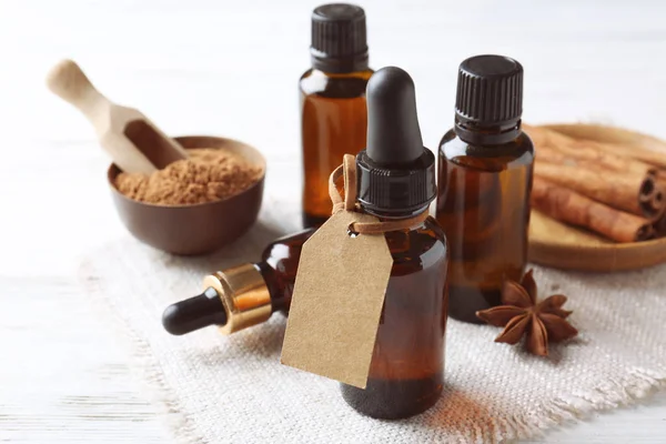 Composition with bottles of cinnamon oil on wooden background — Stock Photo, Image