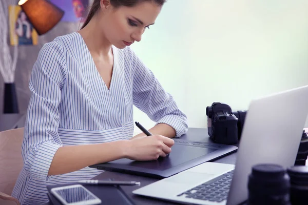 Vrouwelijke fotograaf werkt met grafisch tablet in kantoor — Stockfoto