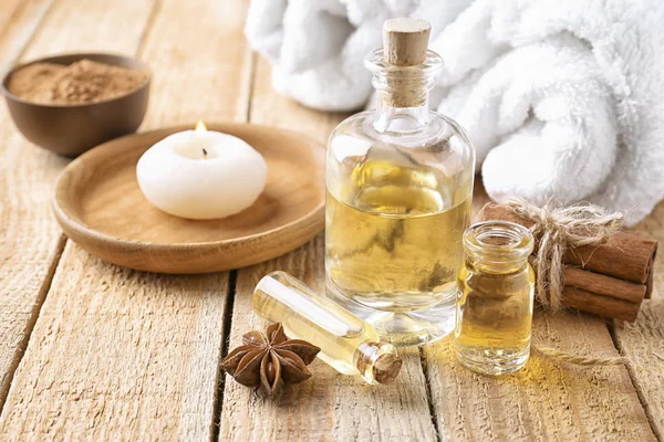 Composition with bottles of cinnamon oil on wooden background