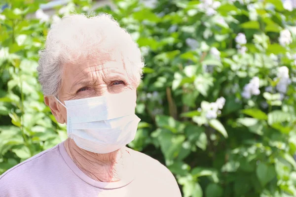 Mujer mayor usando mascarilla facial — Foto de Stock