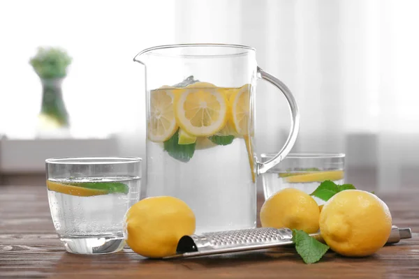 Tillbringare och glasögon med uppfriskande citronvatten — Stockfoto