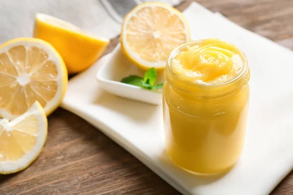 Composition avec délicieux citron caillé dans un bocal en verre sur une table en bois — Photo