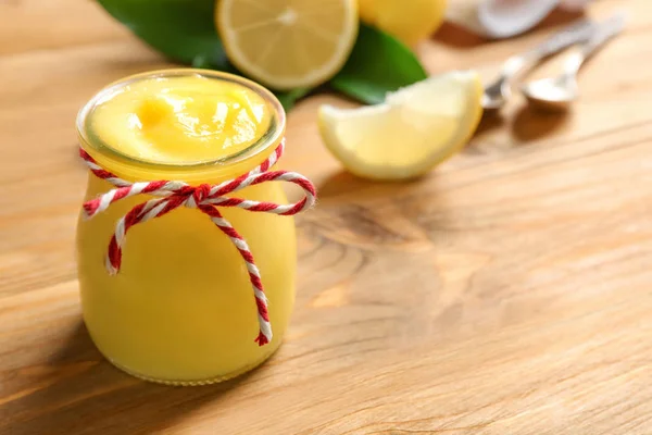 Pot en verre avec délicieux citron caillé sur une table en bois — Photo