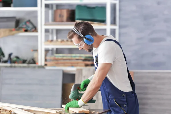 Timmerman zagen van hout in werkplaats — Stockfoto