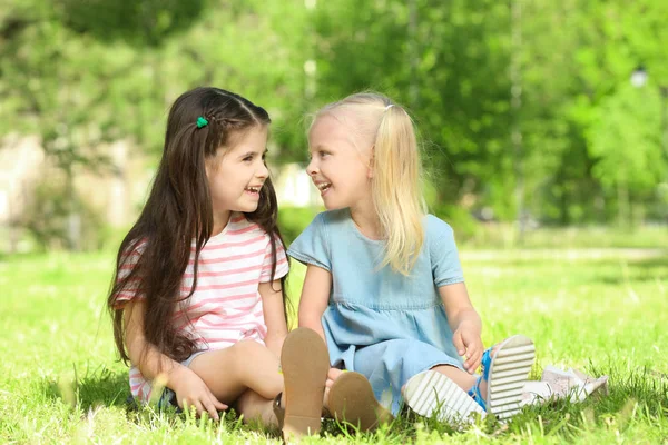 Děvčata sedí na zelené trávě — Stock fotografie