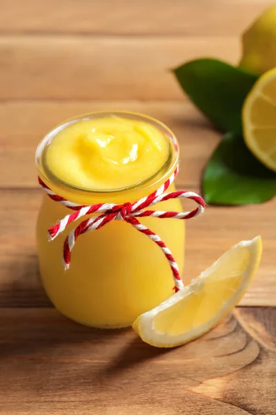 Tarro de vidrio con deliciosa cuajada de limón en la mesa de madera — Foto de Stock