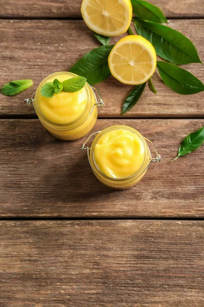 Glasgläser mit leckerem Zitronenquark auf Holztisch — Stockfoto