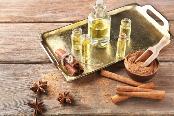 Composition with bottles of cinnamon oil on wooden background — Stock Photo, Image