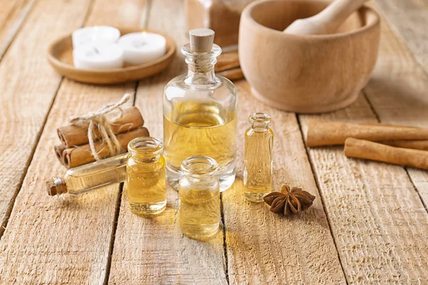 Composition with bottles of cinnamon oil on wooden background — Stock Photo, Image