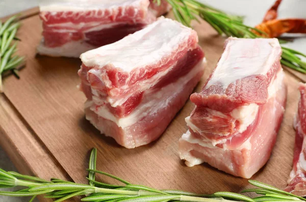 Raw ribs with rosemary on wooden board — Stock Photo, Image