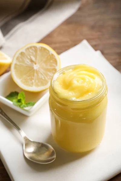 Glass jar with yummy lemon curd on wooden table — Stock Photo, Image