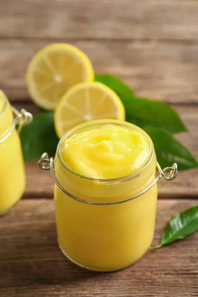 Pot en verre avec délicieux citron caillé sur une table en bois — Photo