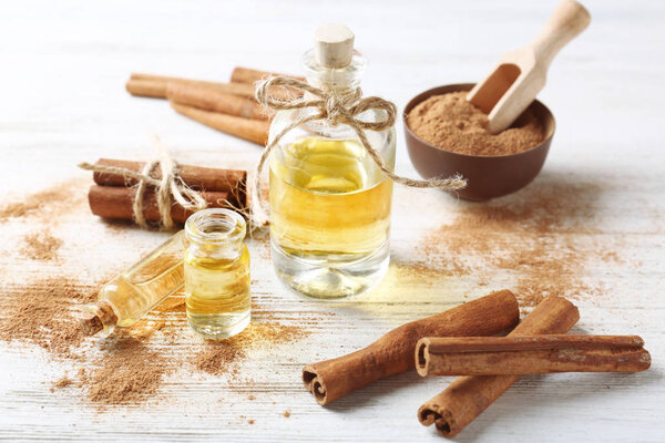 Composition with bottles of cinnamon oil on wooden background