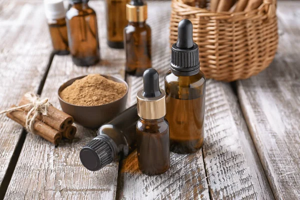 Composition avec des bouteilles d'huile de cannelle sur fond en bois — Photo