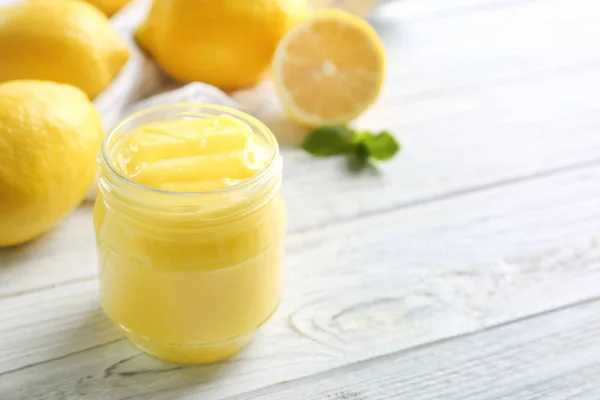 Pot en verre avec délicieux citron caillé sur table en bois blanc — Photo