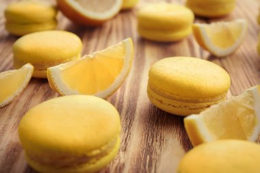 Lezzetli taze macarons ve ahşap masa, tatlı limon dilimleri