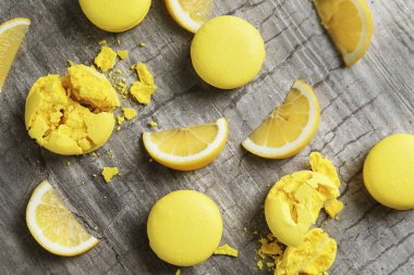 Lezzetli taze macarons ve ahşap masa limon dilimleri