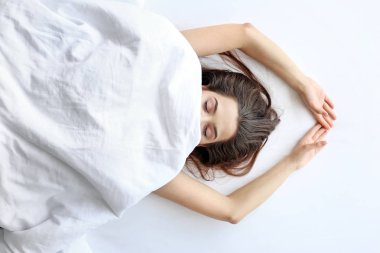 Genç kadın yatakta yatıyor.