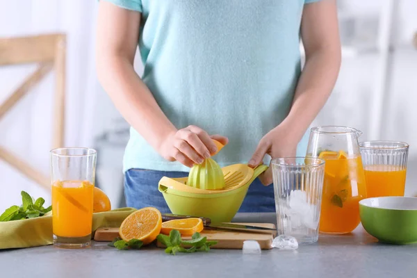 Mujer preparando limonada naranja en la cocina —  Fotos de Stock
