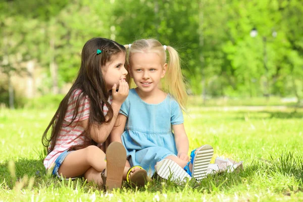 Děvčata sedí na zelené trávě — Stock fotografie