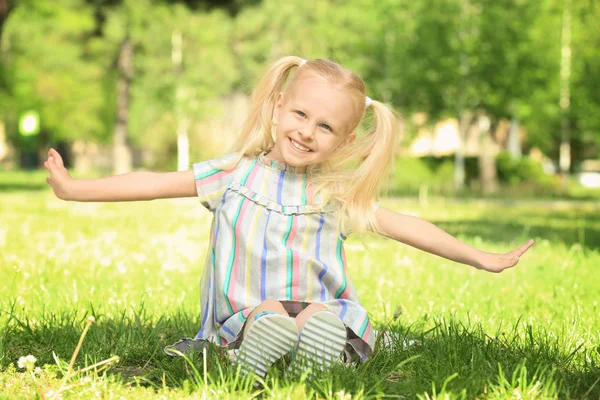 Девушка, сидящая на траве — стоковое фото