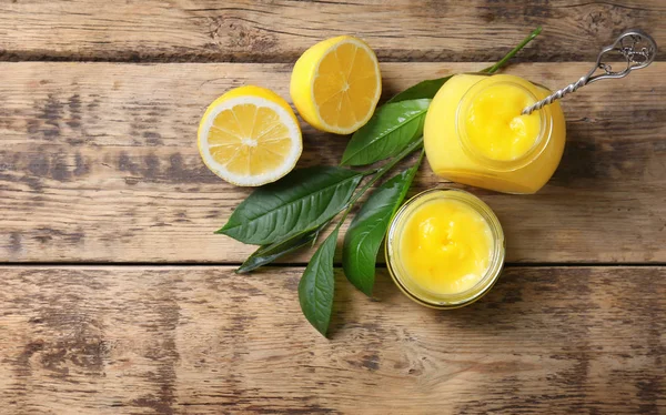 Glazen potten met lekker lemon curd op houten tafel — Stockfoto