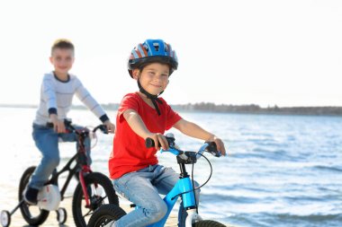 Sevimli küçük çocuklar güneşli günde Nehri yakınında bisiklet sürme