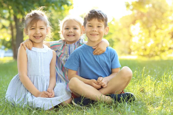 Kinderen zitten op groen gras — Stockfoto