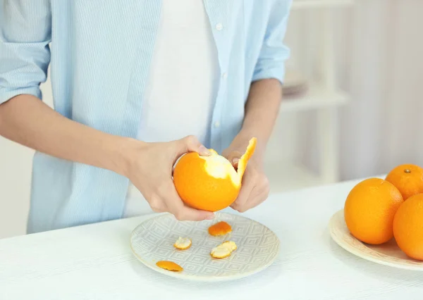 Mãos descascando laranja — Fotografia de Stock