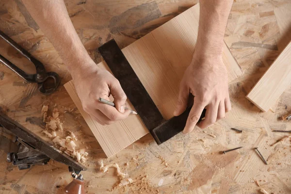 Carpenter marking wooden board — Stock Photo, Image