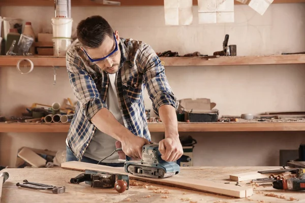 Tukang kayu bekerja dengan sander listrik — Stok Foto