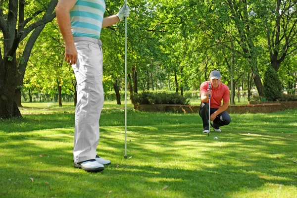 Young men playing golf on course in sunny day — Stock Photo, Image