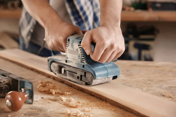 Charpentier travaillant avec une ponceuse électrique — Photo