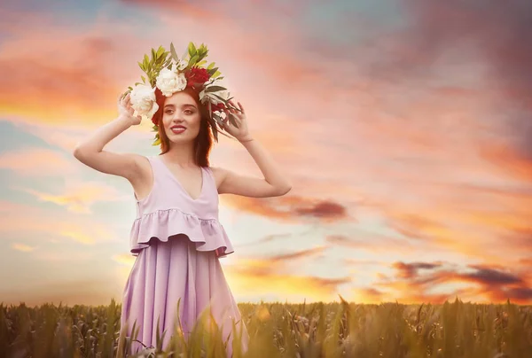 Mladá žena nosí květinový věnec — Stock fotografie